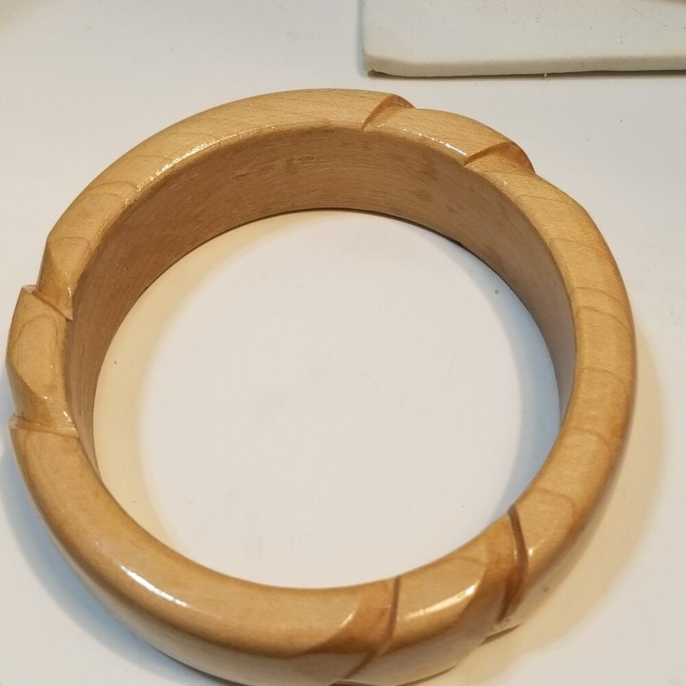 Light wood two and one half inch bangle bracelet with carved design